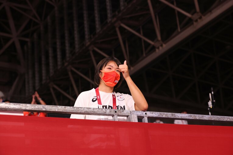 友香子が金メダルを決めると、客席から微笑んだ梨紗子