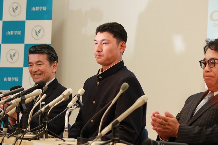 日本ハムから指名を受け、表情を変えないように努める菰田（中央）　©Yusuke Kondo