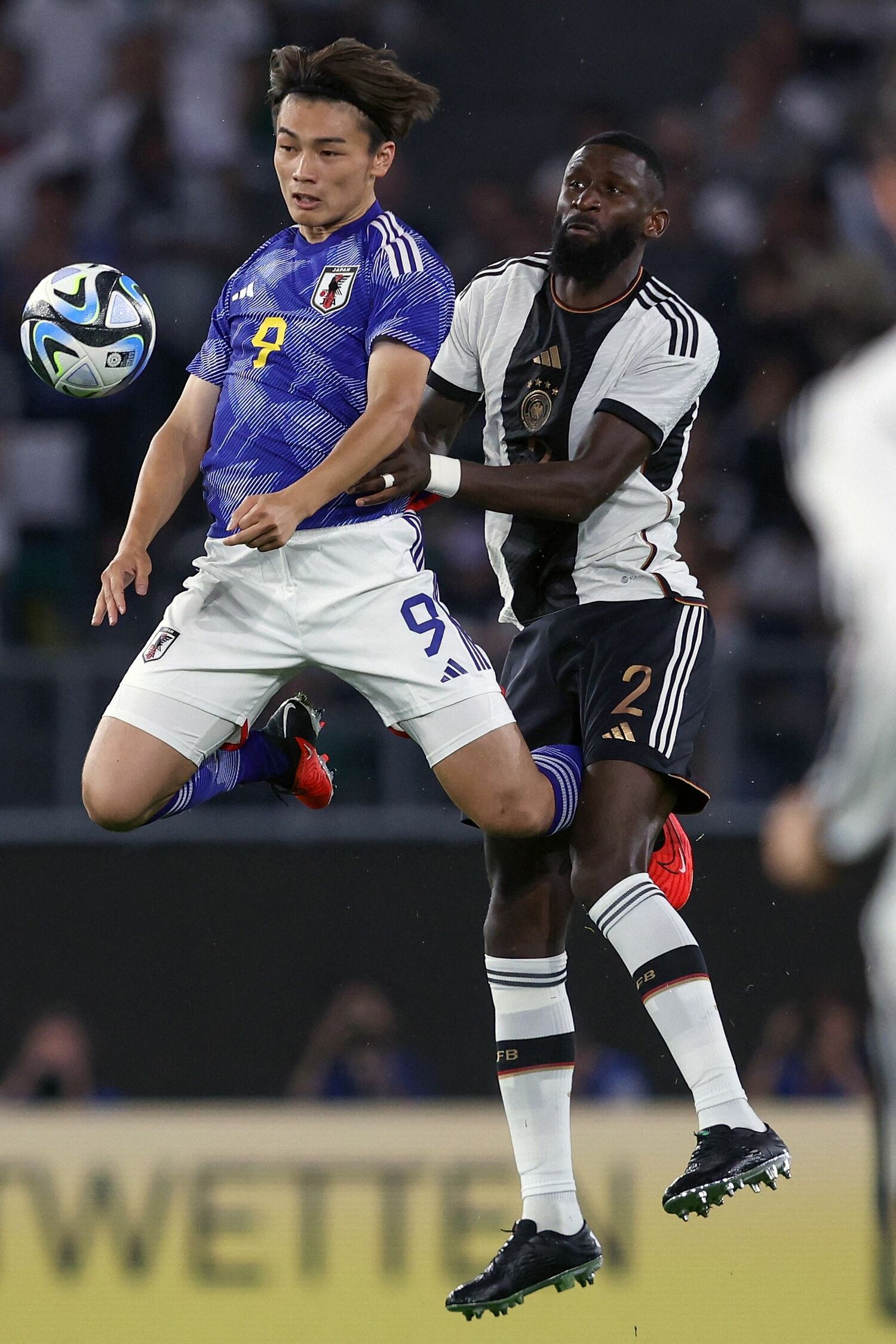 ドイツ代表DFリュディガーを背負いながらボールをキープする上田　©︎JIJI PRESS