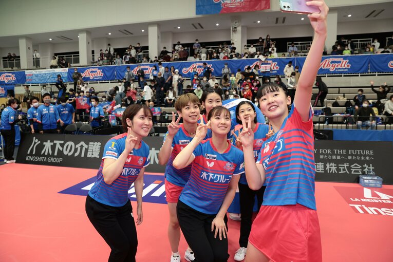 平野美宇らと笑顔で自撮りする張本美和　©AFLO