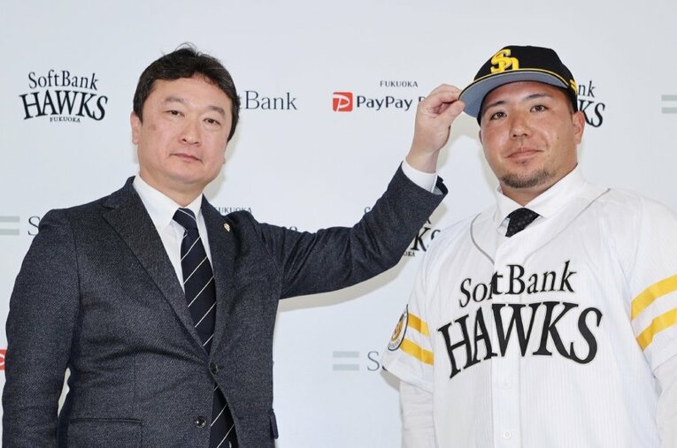 来季からソフトバンクでプレーする山川穂高。左が三笠杉彦GM ／ photograph by JIJI PRESS
