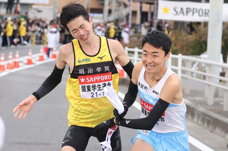 7区を走った明治学院大の栗原舜から襷を受ける東大3年の秋吉拓真。途中までは区間新記録をうかがうペースで突っ込み、好走を見せた ／ photograph by JIJI PRESS