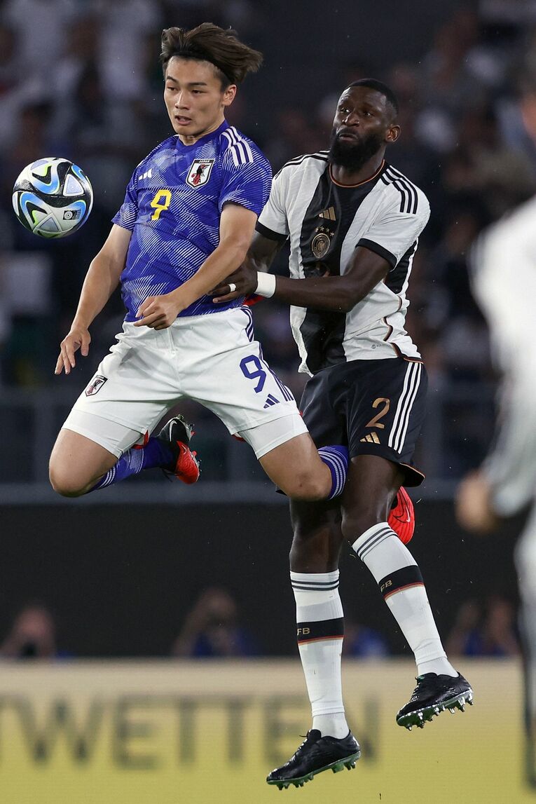 ドイツ代表DFリュディガーを背負いながらボールをキープする上田　©︎JIJI PRESS