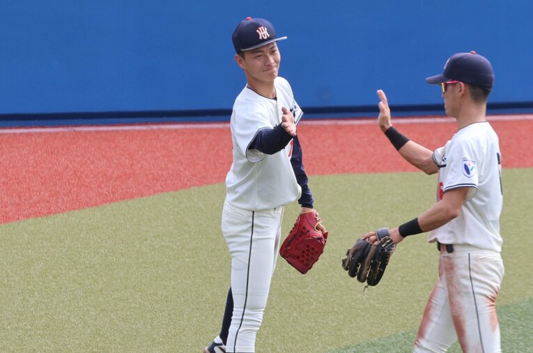 花園大のチームメイトとハイタッチする藤原　©︎Fumi Sawai