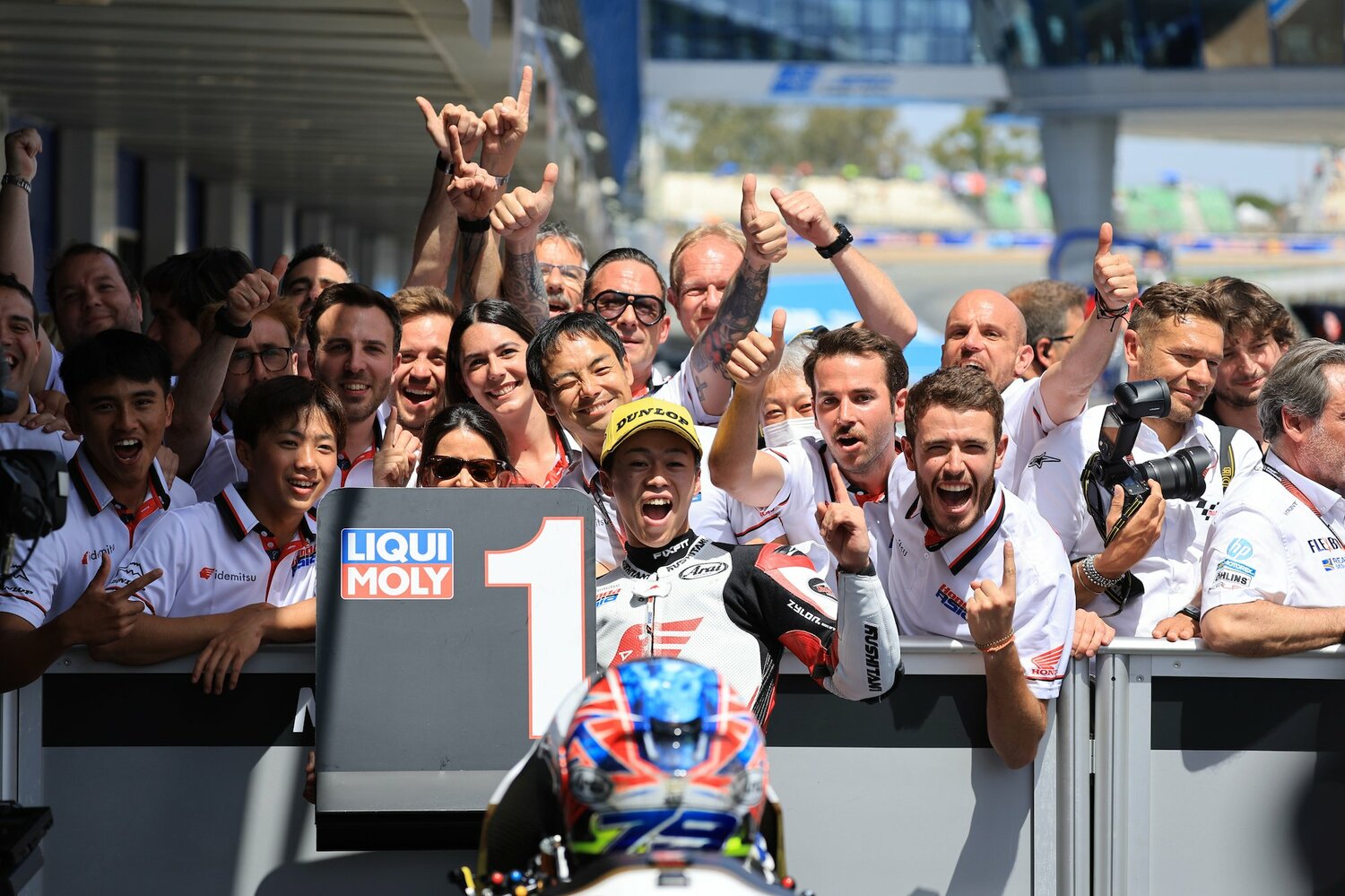 チームスタッフとともに勝利を喜ぶ小椋。小椋の真後ろでウインクするのは14年までMotoGPにフル参戦していた青山博一監督