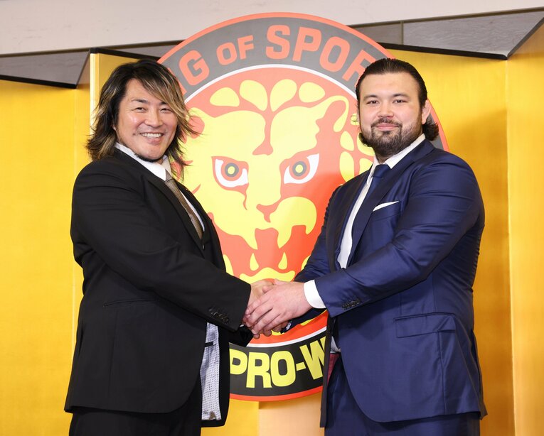 6月23日の入団会見。新日本プロレス社長の棚橋弘至と握手をかわすウルフアロン　©JIJI PRESS