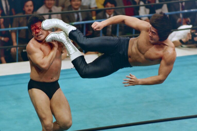 藤波の顔面にドロップキックを放つ武藤。1986年10月13日、後楽園ホール