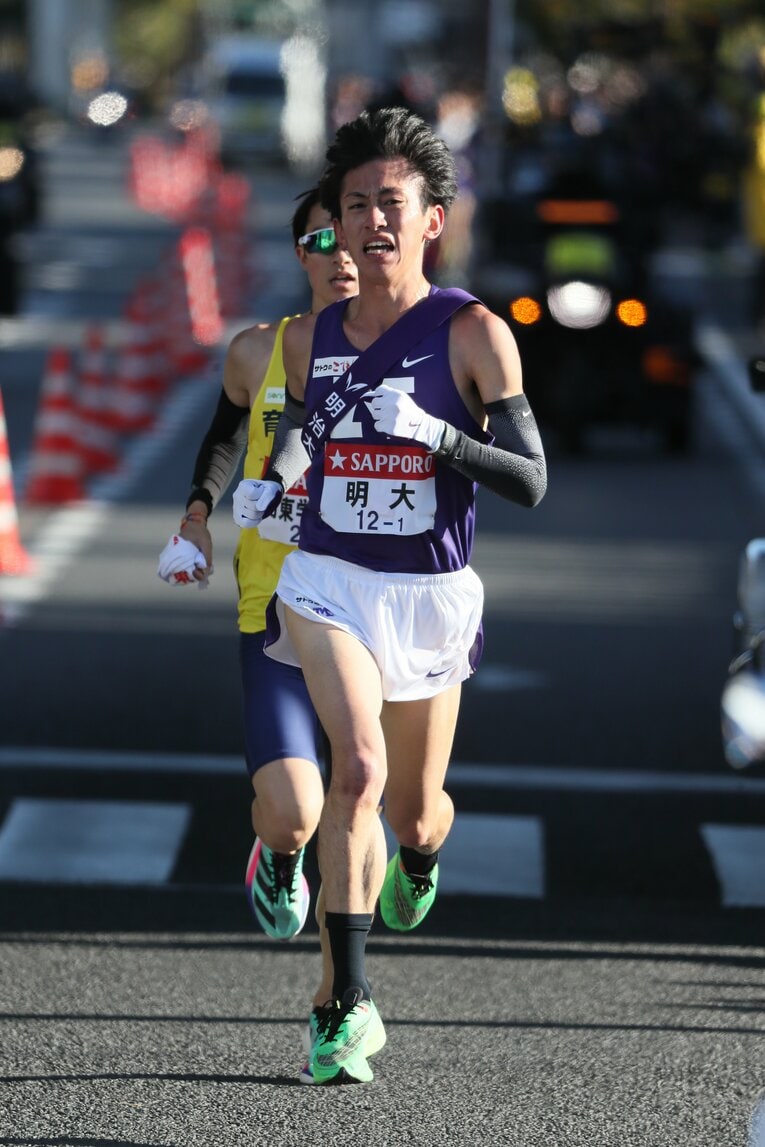 独走状態の新田を明大の富田が追い抜く　©JMPA