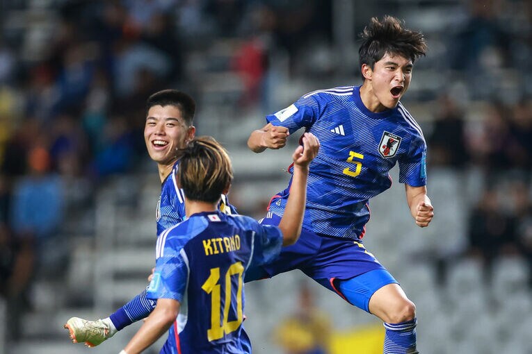 先制点を挙げた山根（5番）を祝福する北野（10番）と高井　©Getty Images