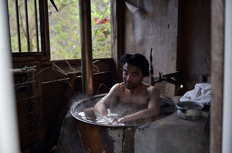 廃村・小蕗の古民家で五右衛門風呂に入る服部文祥さん ／ photograph by Masato Kameda