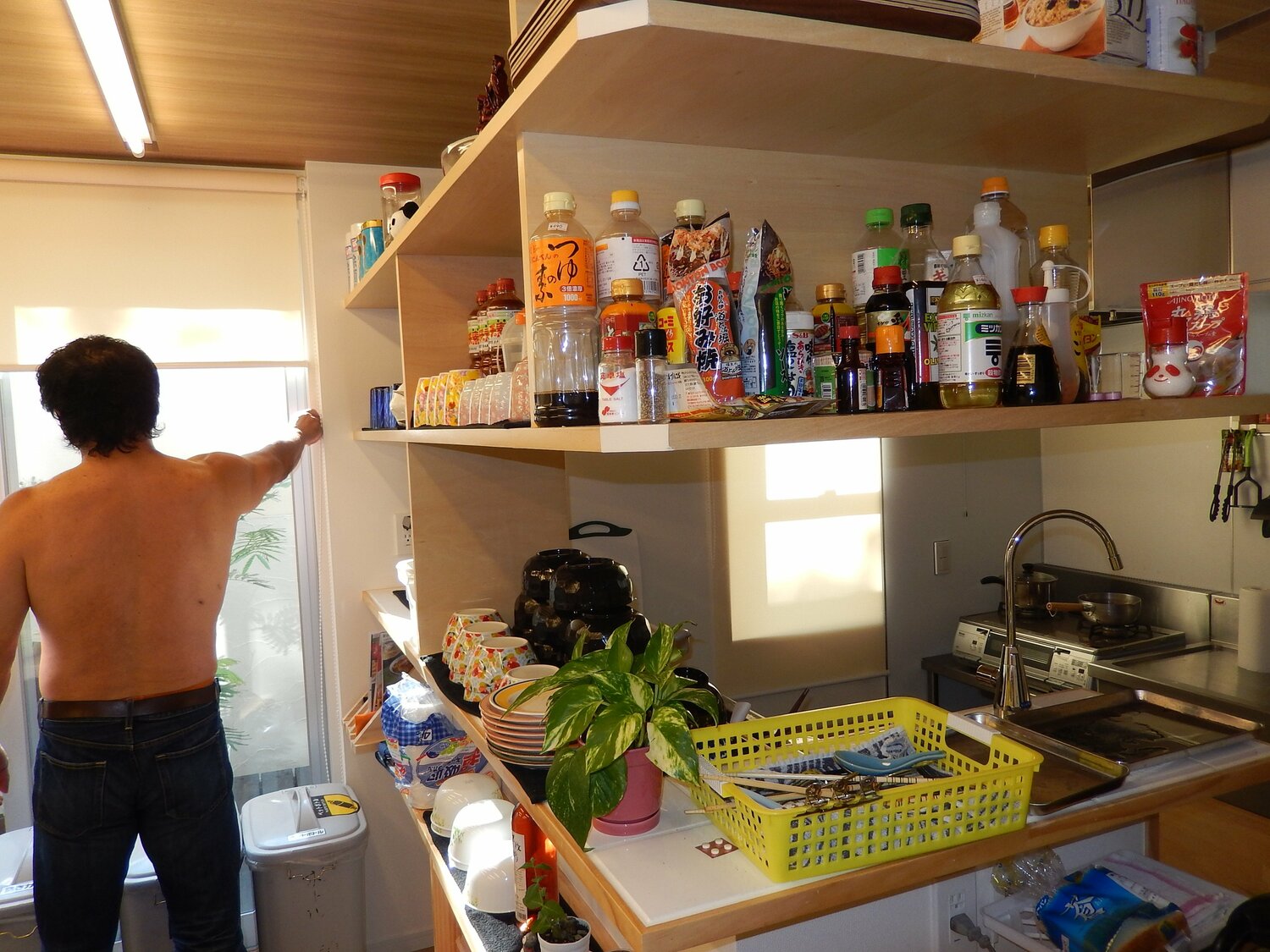 2013年8月、リニューアルされた新日本プロレスの合宿所を案内する小林さん。キッチンには綺麗に調味料が並べられている（筆者撮影）