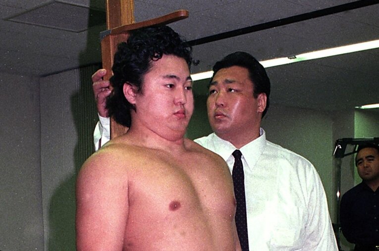 頭にシリコンを入れて新弟子検査に臨む舞の海と、身長を測定する北の湖親方。激痛に耐える舞の海を気遣い、カーソルを少し浮かせていたという ／ photograph by Getty Images