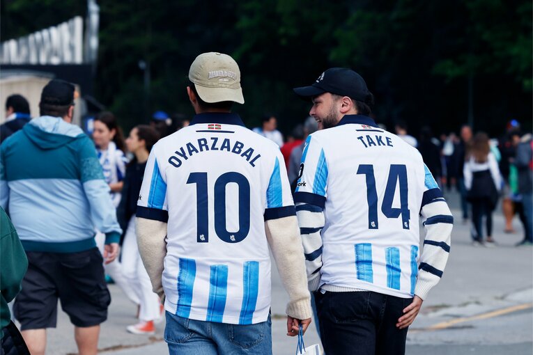 オヤルサバルとタケのユニフォームを着超したファン