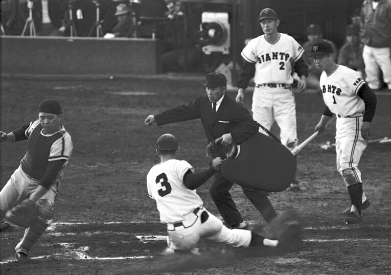 1965年の日本シリーズ第3戦、ホームインする巨人・長嶋茂雄を出迎える王貞治と広岡達朗。南海の捕手は野村克也　©Sankei Shimbun