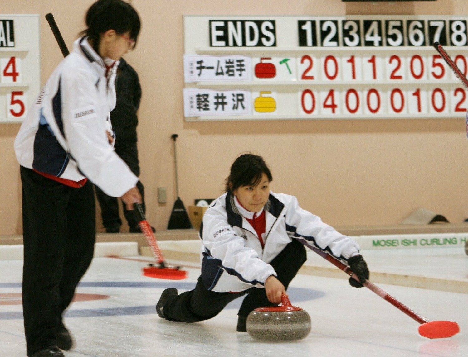 チーム青森戦でストーンを投げる常呂中の吉田知那美。左は吉田夕梨花 ©Kyodo News