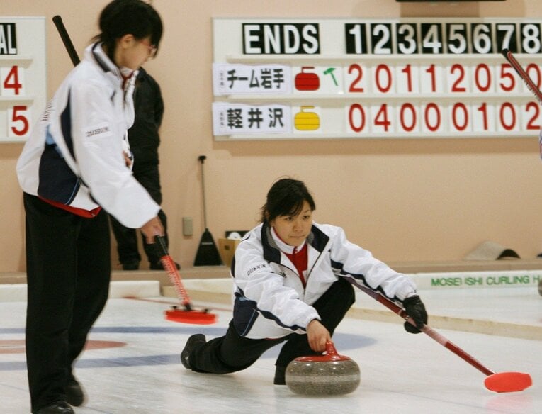 チーム青森戦でストーンを投げる常呂中の吉田知那美。左は吉田夕梨花　©Kyodo News